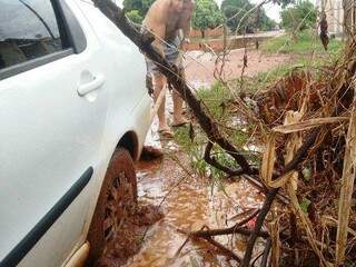 Moradora precisou de ajuda para retirar veículo que atolou em uma poça d&#039;água. (Foto: TL Notícias)