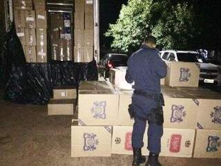 Policial contando as caixas de cigarros apreendidas. (Foto: Porã News) 