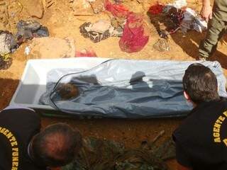 Agentes funerários recolhem restos mortais de vítima (Foto: Adriano Fernandes) 
