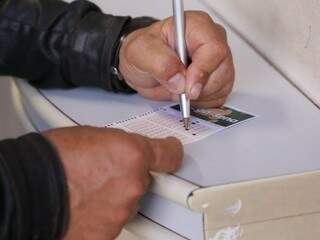 Apostador preenche dezenas em talão (Foto: Kísie Ainoã)