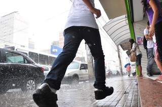 No Centro, garoto corre em meio à chuva, que atinge todas as regiões da cidade. (Foto: João Garrigó)