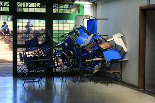 Carteiras quebradas acumuladas no corredor de um dos blocos (Foto: Marina Pacheco)