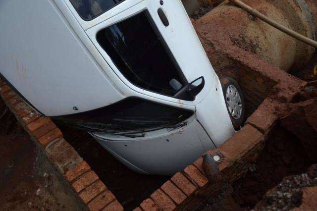 Carro cai em galeria de &aacute;gua e m&atilde;e e filhos saem ilesos