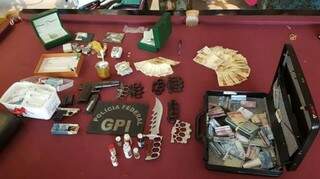 Mala com dinheiro, pistola, faca e diversos produtos apreendidos em operação (Foto: Divulgação/ PF)