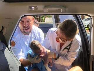Equipe médica segurando Lizzie, bebê que nasceu dentro de veículo em estacionamento de hospital (Foto: Divulgação/Unimed)