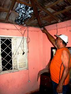 Ramão Ferreira, 71 anos, mostra telhas quebradas com a queda de uma árvore durante o temporal que destelhou casas e derrubou a rede elétrica da cidade. O apagão durou cerca de duas horas. Foto: Débora Pitti