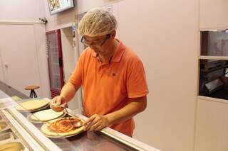 Edson vai montando a pizza conforme o gosto do cliente. (Foto: Thailla Torres)