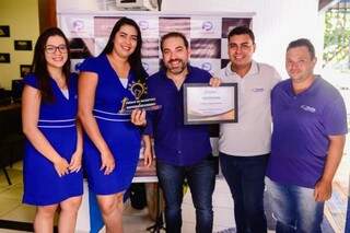 Dono da Visualiza Aluguel de Carros recebendo troféu e certificado.