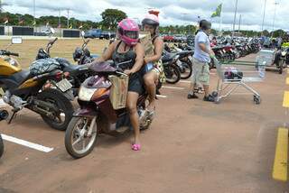 Na necessidade, irmãs se apertam na moto para caberem as compras (Foto: Mariana Lopes)