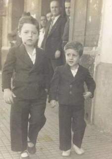 Gabura e o irmão João, andando na 14 de Julho, sob os olhos do pai, ao fundo. (Foto: Arquivo Pessoal)