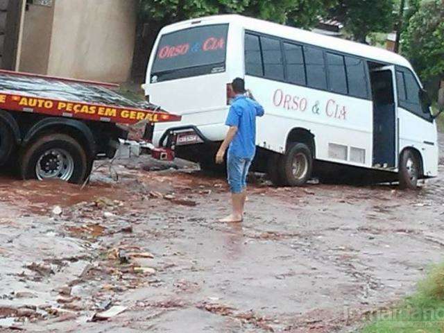 Por excesso de chuva, solo cede e micro-&ocirc;nibus atola em rua