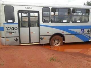 Ônibus ficou preso pela traseira no chão ao passar pelo buraco com água na rua (Foto: Direto das Ruas)