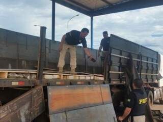 Policiais removem fundo falso onde estavam fardos de maconha (Foto: Divulgação)