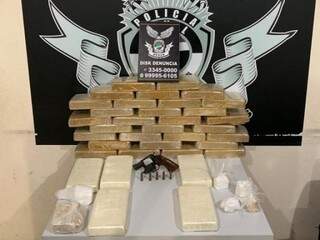 Tabletes de cocaína e a arma encontrados no imóvel. (Foto: Divulgação/Denar) 