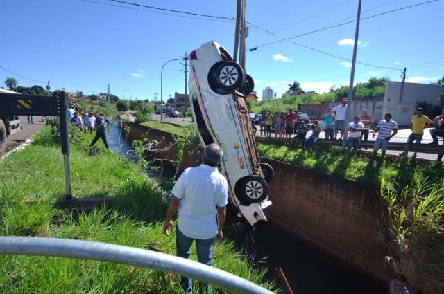 Taxista dorme no volante, bate, arrasta poste por 15m e cai em c&oacute;rrego