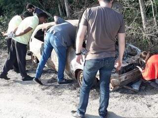 Peritos durante análise do carro onde a ossada estava (Foto: PM Corumbá)