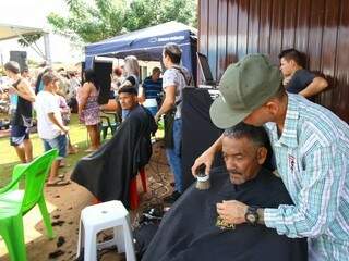 Moradores do Aero Rancho recebem cortes de cabelo gratuitamente, durante ação social neste domingo (28). (Foto: André Bittar)
