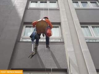 Colaborador da TWA realizando a limpeza de janela em prédio com uso de técnica da cadeira suspensa (Foto: Divulgação)