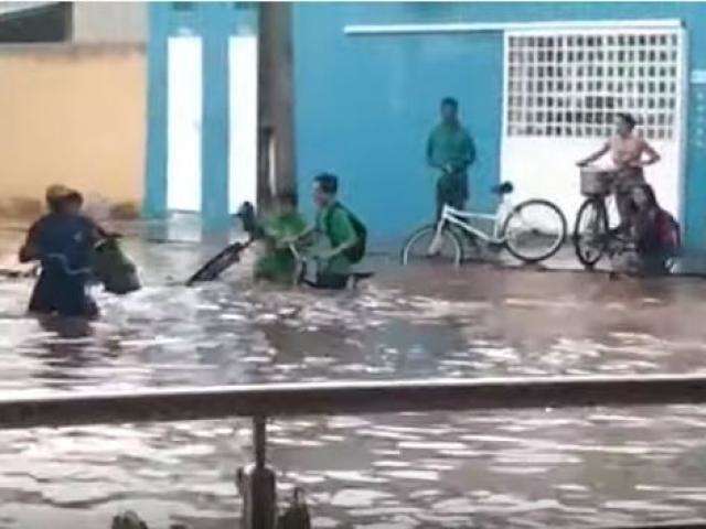 Moradores cruzam ruas com &aacute;gua na cintura ap&oacute;s temporal de 1 hora