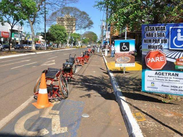 Cadeiras de rodas ocupam vaga de carros para chamar aten&ccedil;&atilde;o de motoristas