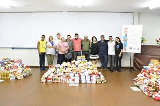Equipes que organizou a campanha ao lado de parte dos alimentos arrecadados (Foto: Divulgação)