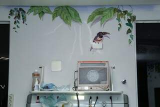 Folhas e pássaro interagindo com aparelhos e tomada da parede (Foto: Kisie Ainoã)