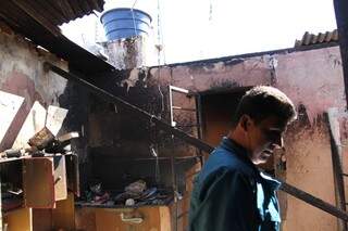 Luciano Souza de Oliveira, 40 anos, nos escombros de casa incendiada (Foto: Saul Schramm)