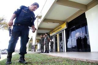 Policial militar procura cápsula de bala deflagrada durante assalto no CMO (Foto: Marcelo Victor)