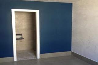 Neste caso, parede azul casada com revestimento que imita concreto foi o toque especial. (Foto: Arquivo/MOB Arquitetos)