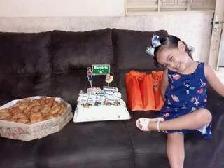 Toda feliz, a pequena Isabela Santana Faria fez foto ao lado do bolo, presentes e pastéis que pediu para dividir com os amiguinhos da sala (Foto: Arquivo Pessoal)