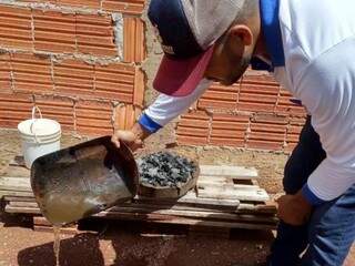 Agente de CCZ elimina recipiente com água parada durante mutirão contra a dengue em Dourados (Foto: Divulgação)