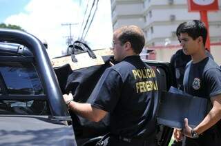 Policiais guardam em viatura material apreendido durante diligência em prédio comercial no centro da cidade. (Foto: Alcides Neto)
