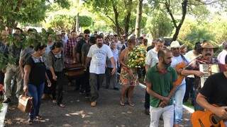 Enquanto os filhos levavam o caixão de Dino Rocha, músicos embalavam a despedida no Memorial Park (Foto: Thailla Torres)