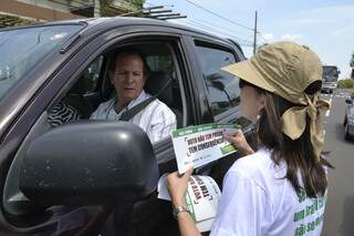 Se protegendo do sol, a procuradora Eleitoral Danilce Vanessa conversa com motorista sobre a divulgação do voto consciente. (Fotos:Minamar Júnior)