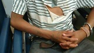 Adolescente algemado em cadeira de delegacia, onde confessou ter matado o primo (Foto: Osvaldo Duarte/Dourados News)