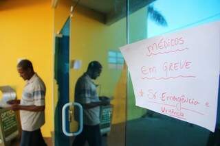 Aviso em porta de posto de saúde informa que o atendimento é só de urgência e emergência. (Foto: Marcos Ermínio)