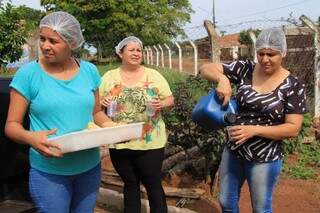 Voluntários distribuindo pães, café, chá e leite as famílias afetas pela chuva (Foto: Marina Pacheco)