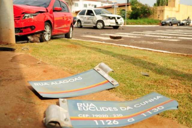 Ap&oacute;s acidente, carro derruba placa e para em cima de cal&ccedil;ada