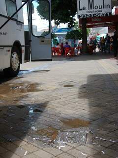 Vazamento no calçadão. Ônibus do Hemosul está estacionado em frente ao esgoto. (Foto: Simão Nogueira)