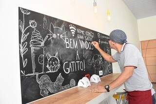 Cleber retoca os desenhos feitos pelos alunos do curso de Artes Cênicas. (Foto: Roberto Higa)