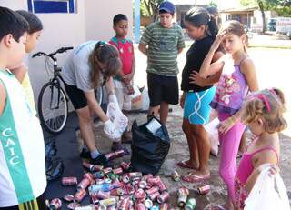 Crianças recolhem materiais que podem acumular água. (Foto: Divulgação)