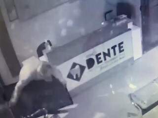 Bandido carregando TV de clínica após arrombamento (Foto: Reprodução)