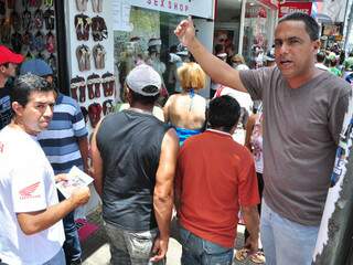 Em cima de banquinho, comerciante tenta vender as rasteirinhas (Foto: João Garrigó)