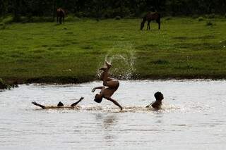 Meninos brincam em lagoa para aplacar a onda de calor que castiga moradores de Campo Grande (Foto: Cleber Gellio)