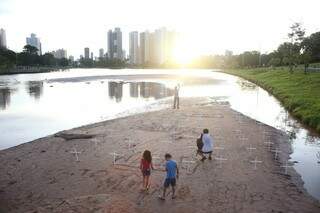 Cruzes de madeira foram colocadas na areia do lago do Parque das Nações que sofre com assoreamento. (Foto: Paulo Francis)
