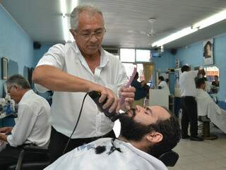 Toninho faz a barba de Thiago, que desde criança frequenta o salão. (Fotos: Minamar Júnior)