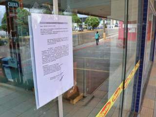 Auto de lacramento pregado na porta de uma das lojas do Grupo Bigolin, em Campo Grande (Foto: Henrique Kawaminami)
