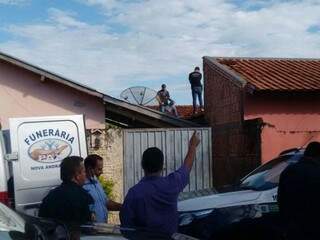 Equipes no telhado da residência para a retirada do corpo. (Foto: Márcio Rogério / Nova News)