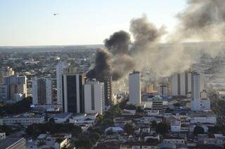 Imagem do alto de um prédio mostra a dimensão do incêndio da loja Planeta Real, no centro de Campo Grande (Foto: Marcos Ermínio)