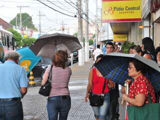 População no Centro se protege com guarda-chuva. (Foto João garrigó)